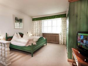 - une chambre avec un lit vert et une télévision dans l'établissement Holiday Flat Gastein near Ski Slopes, à Bad Hofgastein