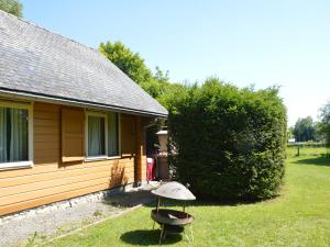 a house with a grill in front of it at Comfortable Chalet in Ovifat near Ski Lift in Waimes