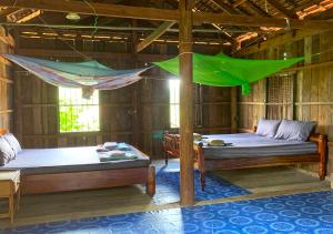 a room with two beds and a hammock in it at Family Batcave Homestay in Battambang