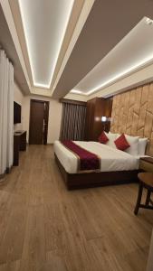 ein Hotelzimmer mit einem großen Bett in der Unterkunft Hotel Pentagon in Ettumānūr