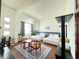 a large bedroom with two beds and a table at LiLLy Hotel DaLat in Da Lat