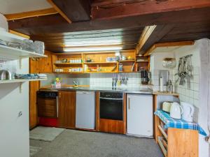 a kitchen with wooden cabinets and white appliances at Chalet in Schwarzenberg am Skilift in Schwarzenberg