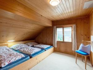 two beds in a wooden room with a window at Chalet in Schwarzenberg am Skilift in Schwarzenberg