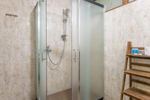 una ducha con puerta de cristal en un baño en Hotel Elibo, en Tiflis 31 fotos más