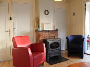 Una sala de estar con dos sillas y una chimenea. en Cosy Holiday Home in Maarheeze with Verandah, en Maarheeze 60 fotos más