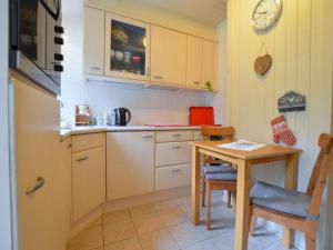 cocina con mesa, mesa pequeña y sillas en Cosy Holiday Home in Maarheeze with Verandah, en Maarheeze
