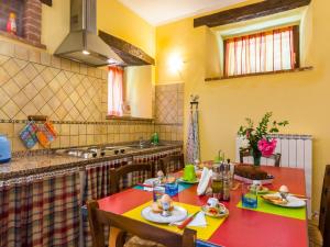a kitchen with a table and chairs and a sink at Farmhouse in hilly area in Gubbio with pool in Biscina