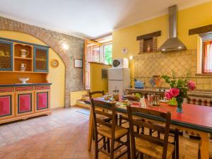 a kitchen with a table and chairs in a room at Farmhouse in hilly area in Gubbio with pool in Biscina
