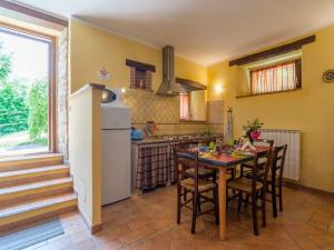 a kitchen with a table and chairs and a refrigerator at Farmhouse in hilly area in Gubbio with pool in Biscina
