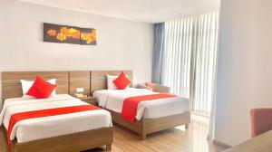 a hotel room with two beds and a window at Maple Leaf Hotel & Apartment in Nha Trang +64 photos