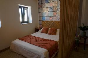 a bedroom with a bed and a wall with tiles at VIELA Guest House Premium in Barcelos