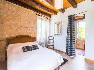 a bedroom with a bed and a brick wall at Elegant Stay in Thémines in Issendolus