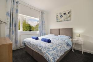 a bedroom with a bed with blue pillows and a window at poplar in Mexborough