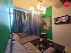 Una sala de estar con un sofá y un televisor. en Skyloft Hotel, en Manila