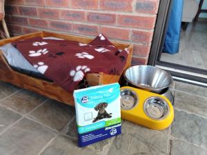 una cuccia per cani con una scatola di cibo per cani e una ciotola di Swallows Rest Cottage KZN a Scottburgh