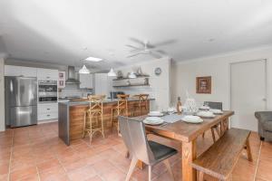 ビンセンチアにあるBliss at Jervis Bay - pet-friendly Vincentia homeのキッチン、ダイニングルーム(木製テーブル付)