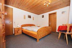 a bedroom with a wooden bed and a wooden ceiling at Haus Helene in Sankt Gallenkirch