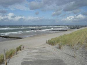 a sandy beach with a path leading to the ocean at Nordlicht - nahe der Kurstraße und dem Reha Zentrum in Graal
