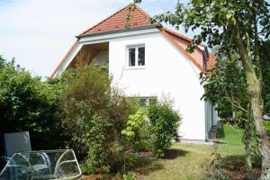 a white house with a red roof at Nordlicht - nahe der Kurstraße und dem Reha Zentrum in Graal +10 photos