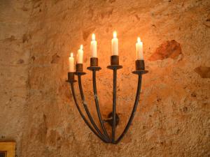 Un candelabro colgado en una pared con velas encendidas. en Pleasant Holiday Home in Kemmenau with Sauna, en Kemmenau