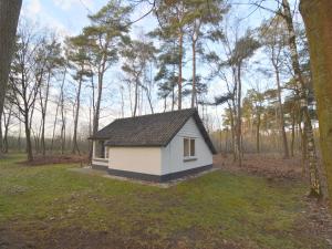 a small house in the middle of a field at Completely detached bungalow in a nature-filled park by a large fen in Stramproy +96 photos
