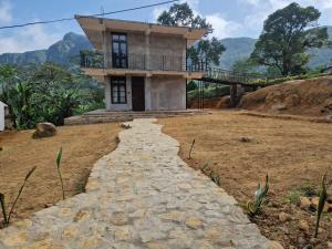 a house on a hill with a stone path leading to it at Aruni Villa - Knuckles Range in Pusse-Ela