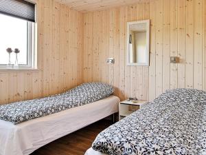 two beds in a room with wood paneled walls at 5 star holiday home in Bogense in Bogense +24 photos