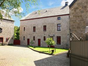 an old stone building with red doors and a fence at Luxury Holiday Home in Melreux-Hotton with Sauna in Melreux
