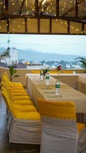 Una mesa larga con sillas amarillas y botellas de agua. en Hotel Skyking, en Dehradun 42 fotos más