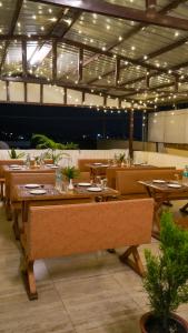 Un restaurante con mesas y sillas de madera y luces. en Hotel Skyking, en Dehradun