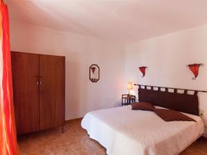 a bedroom with a bed and a wooden cabinet at Cosy Holiday Home in Cargèse Corse-du-Sud near Sea in Cargèse +32 photos