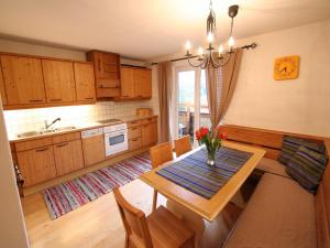 Una cocina con una mesa con un jarrón de flores encima. en Wonderful Apartment in Hopfgarten im Brixental with Parking, en Hopfgarten im Brixental