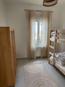 a room with two bunk beds and a window at La petite bleue, Villa 300 m de la mer in Agon Coutainville