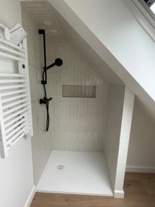 a bathroom with a shower under the stairs at La petite bleue, Villa 300 m de la mer in Agon Coutainville +29 photos
