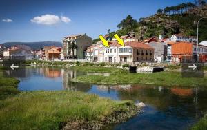 una città con edifici e un fiume con case di APTOS SOLAINA O PINDO a O Pindo