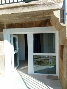 a window in a stone building with a door at Casa con encanto Ribeira Sacra in Sistín +17 photos