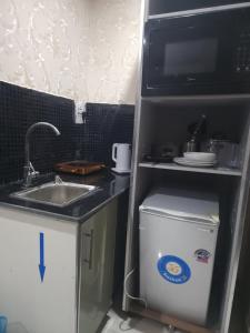 a kitchen with a refrigerator with a sink and a microwave at Marina Apartments in Lagos