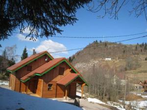a log cabin in the snow with a mountain in the background at Chalet in Ventron near La Bresse Ski Area in Ventron