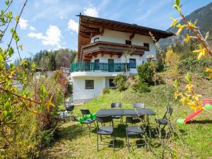 une table et des chaises devant une maison dans l'établissement Comfortable Apartment in Mayrhofen with Garden, à Mayrhofen