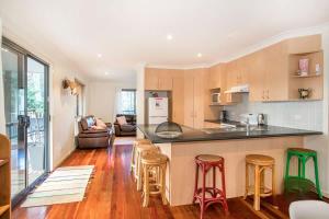 a kitchen and living room with a counter and stools at Bawley retreat in Bawley Point