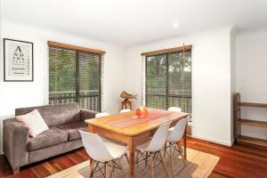 a living room with a wooden table and a couch at Bawley retreat in Bawley Point +13 photos