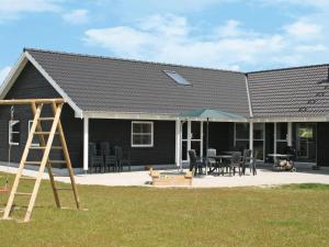 una casa negra con una mesa y sillas en Luxury Villa with Pool - By Traum Ferienwohnungen, en Bøtø By