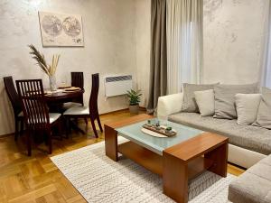 a living room with a couch and a table at Cozy Modern Apartment Podgorica in Podgorica +6 photos