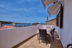Un balcón con mesa y sillas y vista al agua. en House Ruzica, en Mali Lošinj
