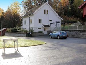 a small blue car parked in front of a white house at 8 person holiday home in Lindesnes in Tryland