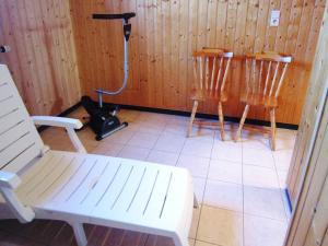 una stanza con due sedie in legno e un aspirapolvere di Luxury gite with sauna in Baugnez Malmedy ad Arimont