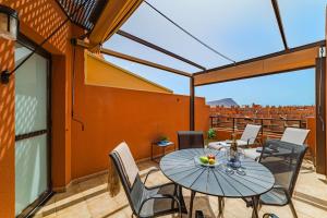 a patio with a table and chairs on a balcony at Sotavento Horizon Views Suite in La Tejita