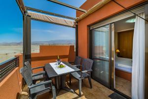 a balcony with a table and chairs and a bedroom at Sotavento Horizon Views Suite in La Tejita