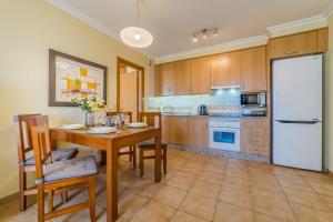 a kitchen with a wooden table and a white refrigerator at Sotavento Horizon Views Suite in La Tejita +30 photos