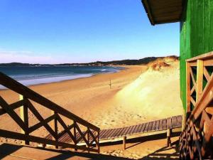 a beach with a green building and the ocean at Apartment with Sea Views in Sanxenxo